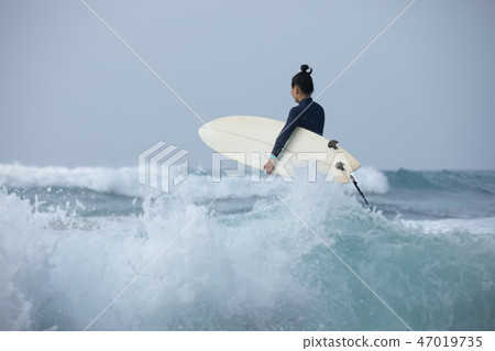 Woman surfer with surfboard going to surf Woman surfer with surfboard going to surf 47019735