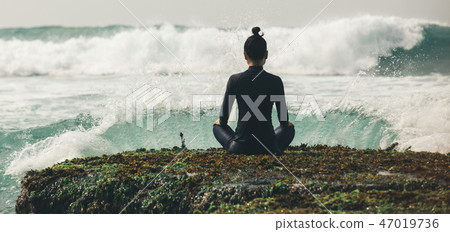 Yoga woman meditation at the seaside cliff edge   47019736