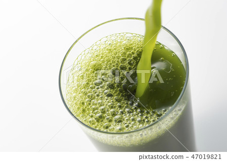 Put the green juice in the glass 47019821