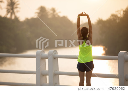 Woman runner warming up outdoors  47020062