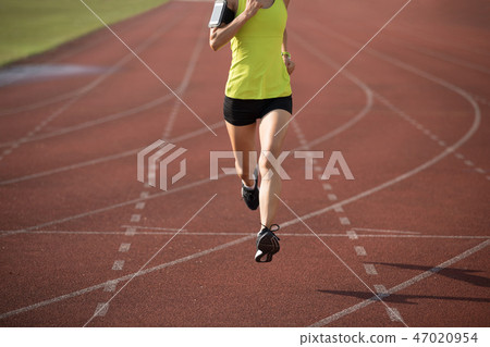 Fitness sportswoman running on stadium race tracks 47020954