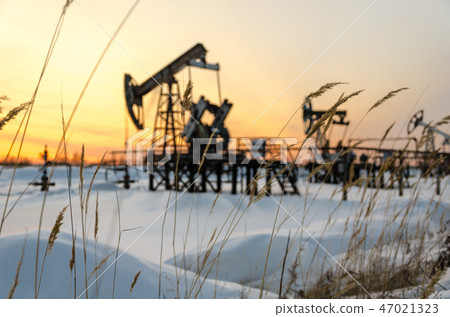 Oilfield during sunset in winter time Oilfield during sunset in winter time 47021323