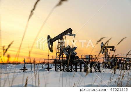 Oilfield during sunset in winter time Oilfield during sunset in winter time 47021325
