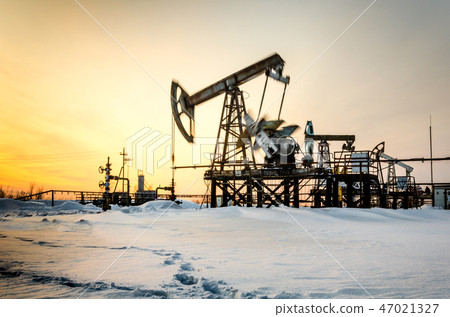 Oilfield during sunset in winter time Oilfield during sunset in winter time 47021327