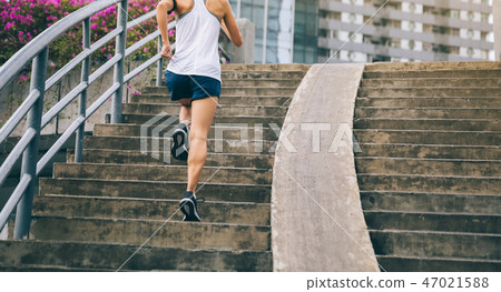 woman runner sportswoman running up city stairs 47021588