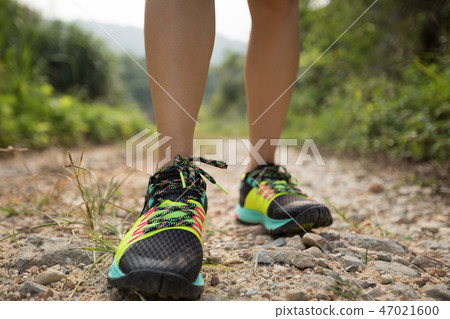 woman trail runner legs running on forest 47021600