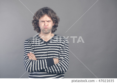 Funny comic man pouts lips and cheeks makes angry grimace, foolishes after all day working. Clueless 47021635