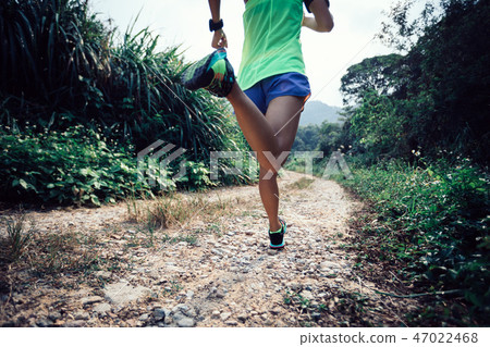 young fitness woman trail runner running on forest 47022468