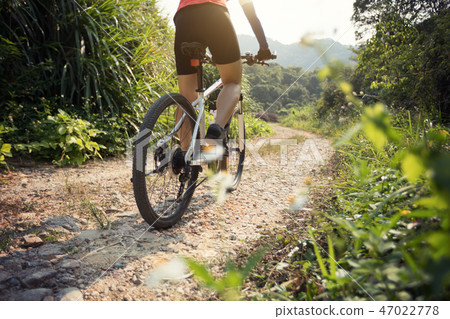 Woman cyclist riding mountain bike on rocky trail  47022778