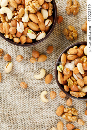 Mix of various nuts in a wooden cup against Mix of various nuts in a wooden cup against 47022879
