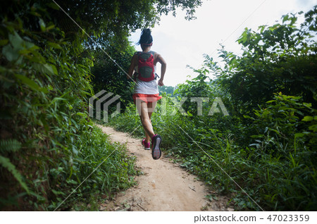 trail runner running on tropical forest trail trail runner running on tropical forest trail 47023359