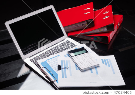 Office workplace with documents and stationery near red folders Office workplace with documents and stationery near red folders 47024405