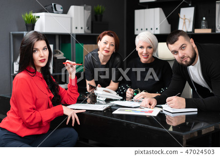 Smiling employees talking in workplace Smiling employees talking in workplace 47024503
