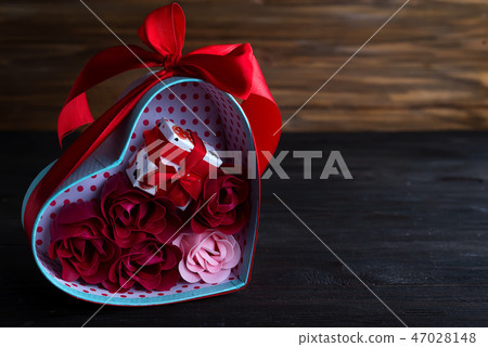 Valentines background with bouquet rose in gift box and mini gift box on dark wooden background Valentines background with bouquet rose in gift box and mini gift box on dark wooden background 47028148