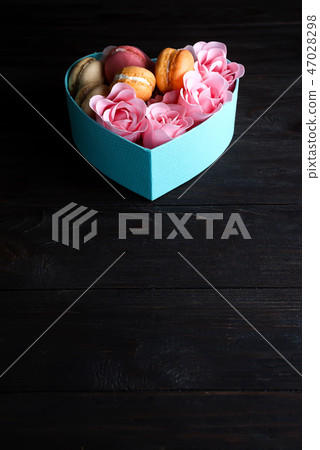 Macaroons in box. Festive round blue box with cookies and Rose on dark wooden background, copy space Macaroons in box. Festive round blue box with cookies and Rose on dark wooden background, copy space 47028298