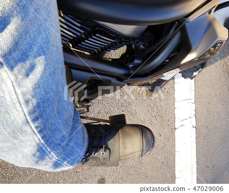 The foot of the biker who stopped at the motorcycle white line 47029006
