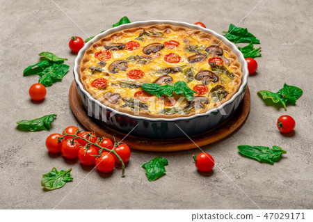 Baked homemade quiche pie in ceramic baking form on concrete background Baked homemade quiche pie in ceramic baking form on concrete background 47029171