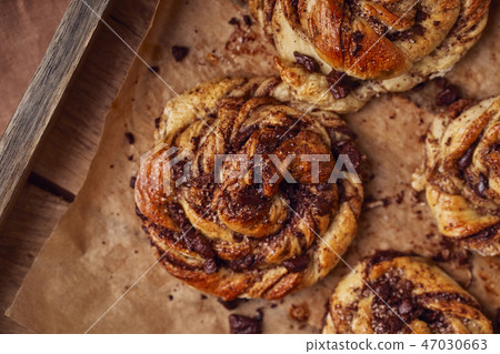 Buns with chocolate and cinnamon as cake food concept. Top view. Close up image Buns with chocolate and cinnamon as cake food concept. Top view. Close up image 47030663