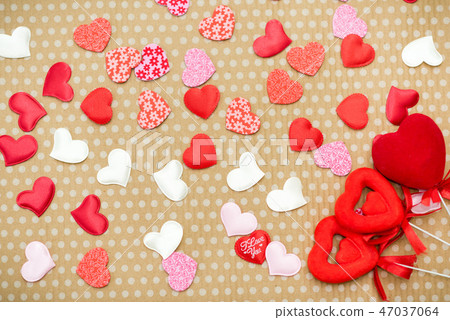 Many red hearts lie on an old cardboard background in white peas. Many red hearts lie on an old cardboard background in white peas. 47037064