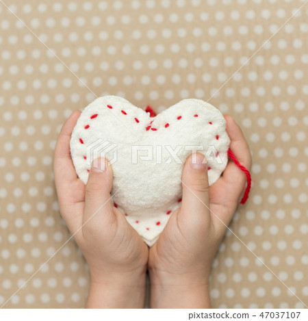 A child holding a white heart handmade A child holding a white heart handmade 47037107