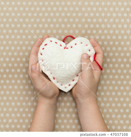 A child holding a white heart handmade 47037108