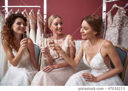 Happy young brides clanging glasses of champagne 47038213