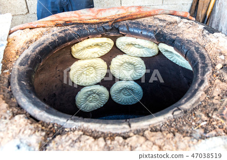 Traditional Uzbek flatbread baking in the tandir 47038519