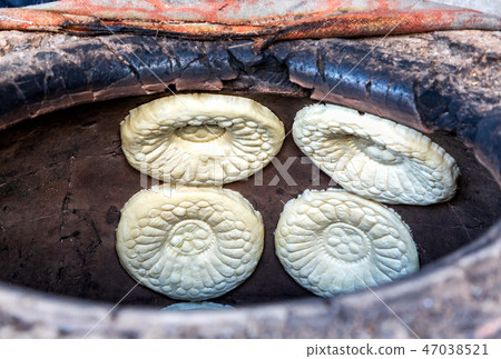 Traditional Uzbek flatbread baking in the tandir Traditional Uzbek flatbread baking in the tandir 47038521