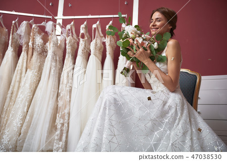 Happy bride in wedding dress enjoying flowers Happy bride in wedding dress enjoying flowers 47038530