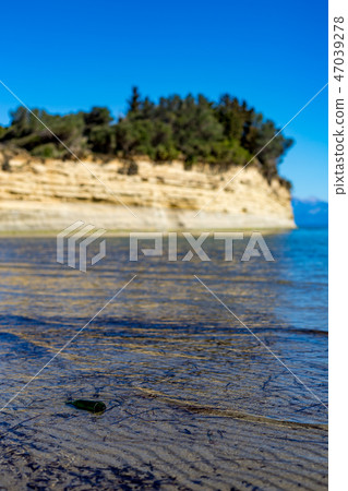 Empty green glass bottle thrown at Corfu beach 47039278