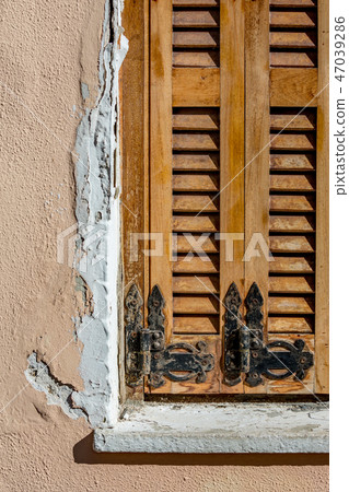 Black wrought iron hinges on old wooden windows 47039286