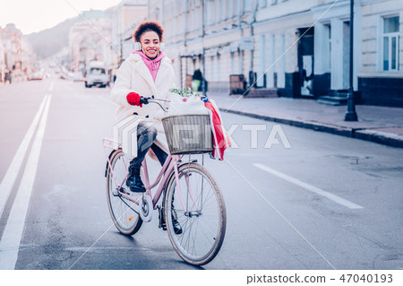 Positive delighted female person riding her bicycle 47040193