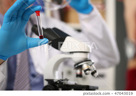 Male hand in blue protective gloves holding Male hand in blue protective gloves holding 47043019