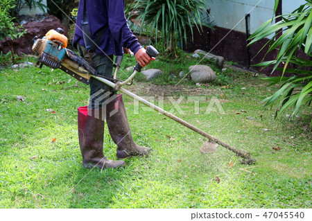 Asian men are using a lawn mower in the garden. Asian men are using a lawn mower in the garden. 47045540