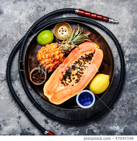 Smoking hookah with tobacco papaya Smoking hookah with tobacco papaya 47045596