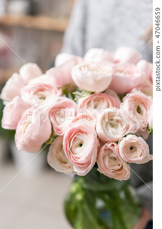 Persian buttercup in glass vases in womens hands. Bunch pale pink. the concept of a florist in a 47046659