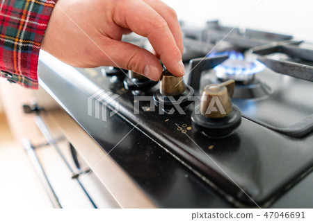 A man lighting the gas-stove with by means of automatic electric ignition. Modern gas burner and hob 47046691