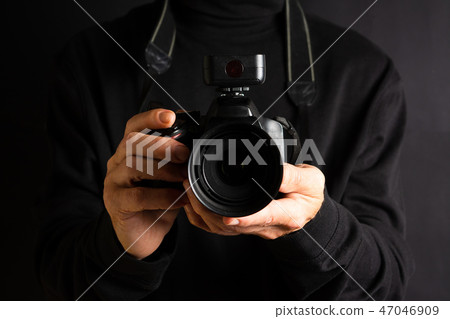 Person holding a camera close up 47046909