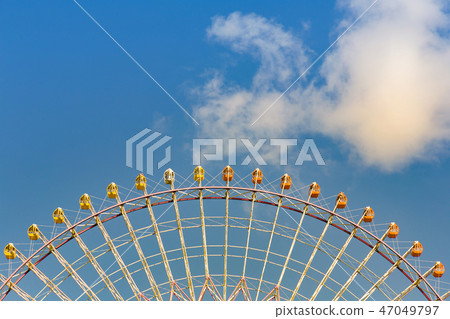 Path of modern giant ferris wheel against blue sky 47049797