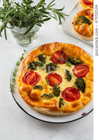 Vegetable pie quiche with broccoli, tomatoes and soft cheese on white background. 47050584