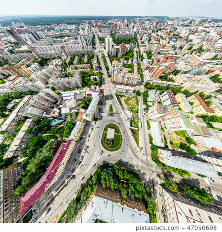 Aerial city view with crossroads and roads, houses, buildings, parks and parking lots. Sunny summer 47050698