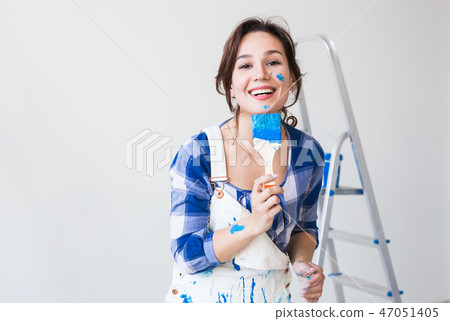 Redecoration, renovation and people concept - young woman painting the wall and looks like very 47051405