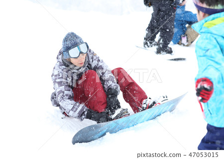A woman enjoying snowboarding A woman enjoying snowboarding 47053015