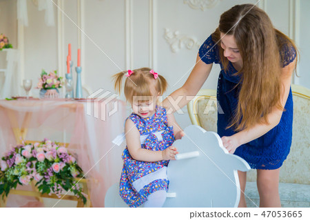 Little girl playing on wooden rocking horse 47053665