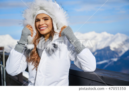 Smiling young woman in white coat and fur 47055350