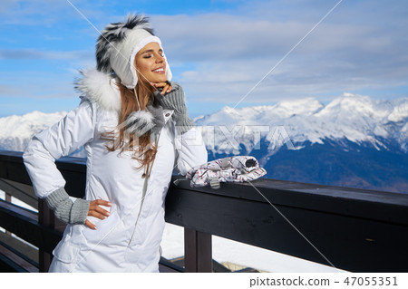 Smiling young woman in white coat and fur 47055351