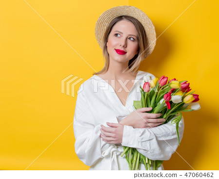 woman in white shirt and hat with fresh springtime tulips woman in white shirt and hat with fresh springtime tulips 47060462