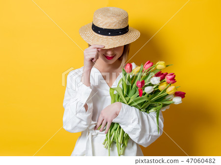 woman in white shirt and hat with fresh springtime tulips woman in white shirt and hat with fresh springtime tulips 47060482