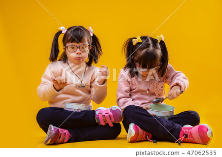 Dark-haired unusual children with chromosome abnormality eating breakfast Dark-haired unusual children with chromosome abnormality eating breakfast 47062535