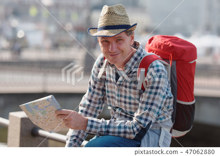 Tourist with backpack and city plan 47062880